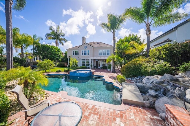 view of pool with a pool with connected hot tub and a patio