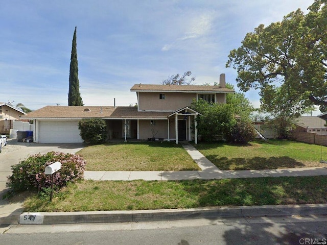 view of front of house with an attached garage, driveway, fence, and a front lawn