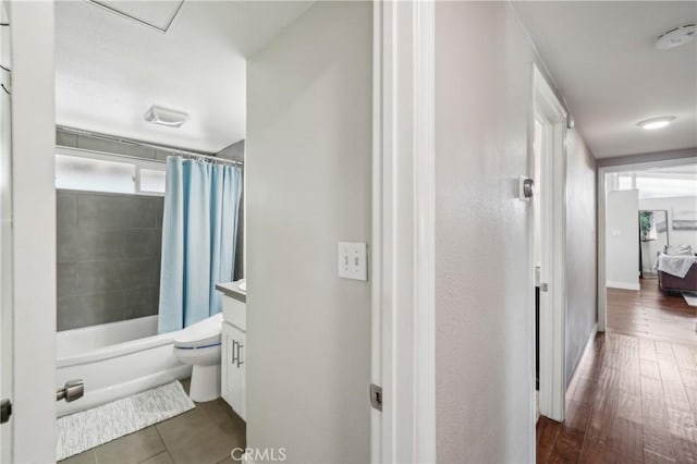 corridor featuring baseboards and dark wood finished floors