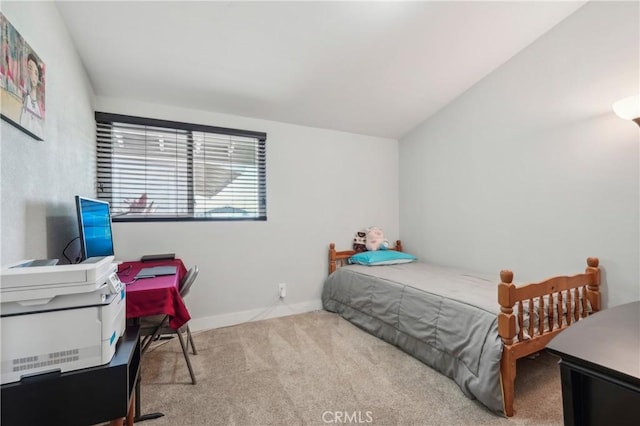 carpeted bedroom featuring lofted ceiling and baseboards