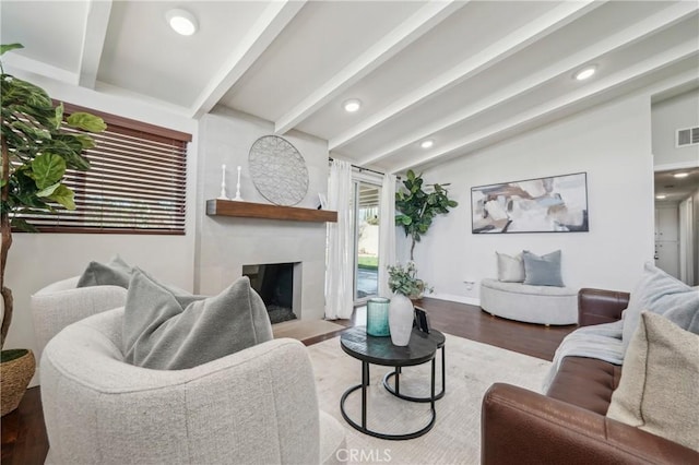 living area with recessed lighting, visible vents, lofted ceiling with beams, a fireplace with flush hearth, and wood finished floors