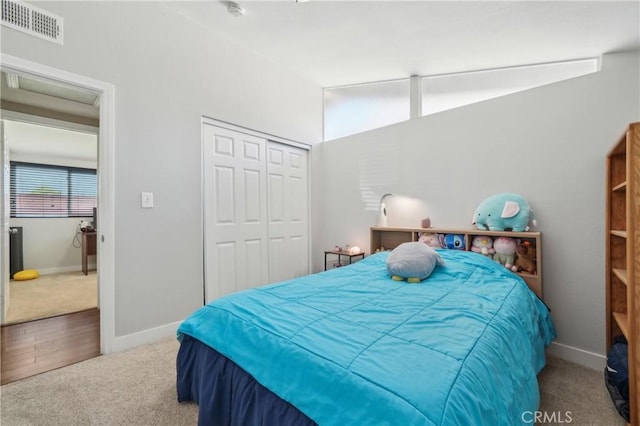 carpeted bedroom featuring lofted ceiling, baseboards, visible vents, and a closet