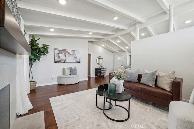 living room featuring lofted ceiling with beams, recessed lighting, wood finished floors, a fireplace with flush hearth, and baseboards