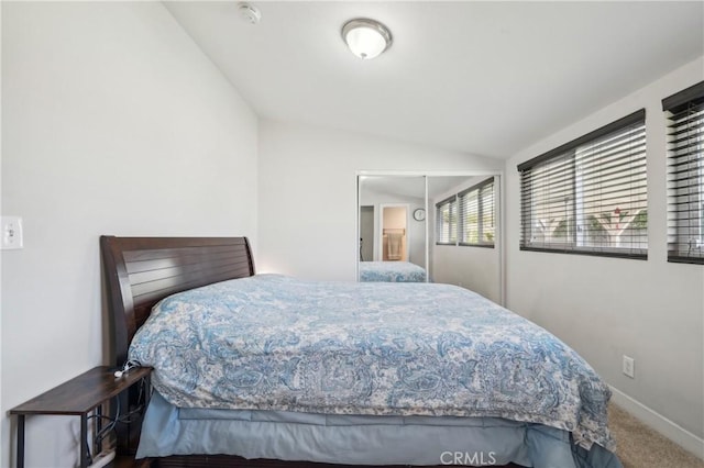 carpeted bedroom featuring vaulted ceiling and baseboards