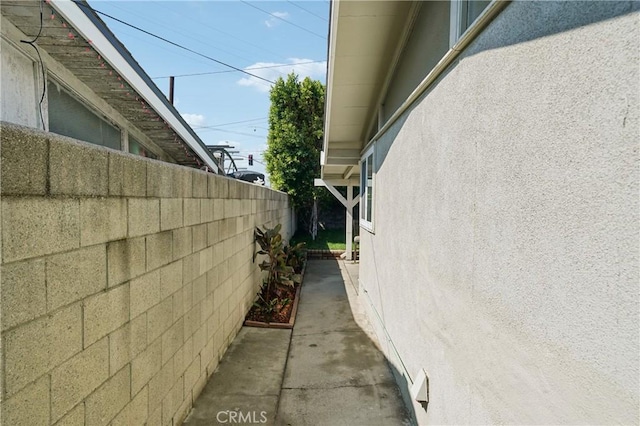 view of property exterior featuring fence and stucco siding