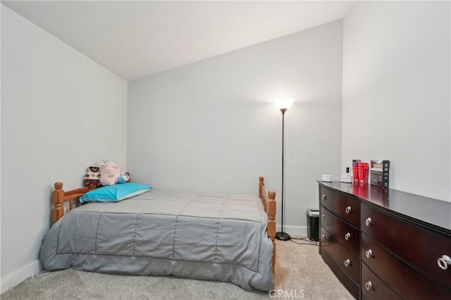 bedroom with baseboards, vaulted ceiling, and light colored carpet