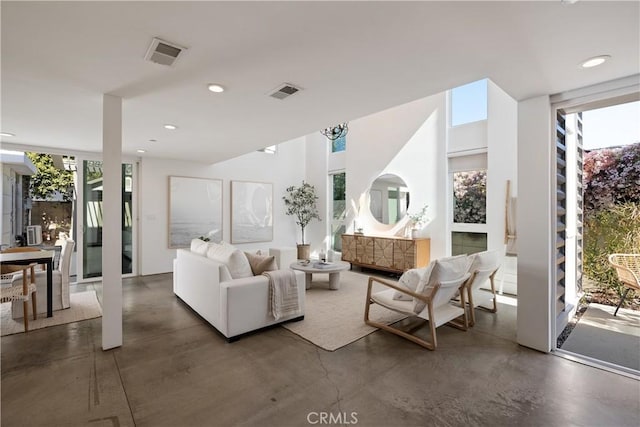 living area with concrete flooring, recessed lighting, and visible vents