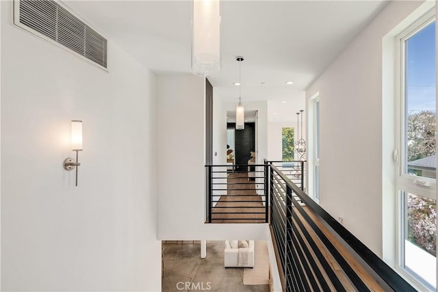 corridor featuring plenty of natural light, visible vents, and an upstairs landing