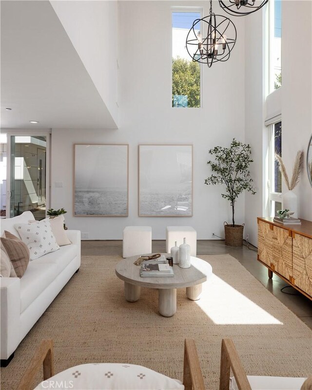 living room featuring a towering ceiling and a notable chandelier