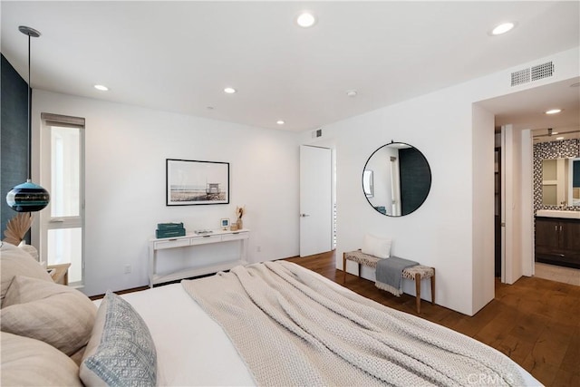 bedroom with recessed lighting, visible vents, connected bathroom, and wood finished floors