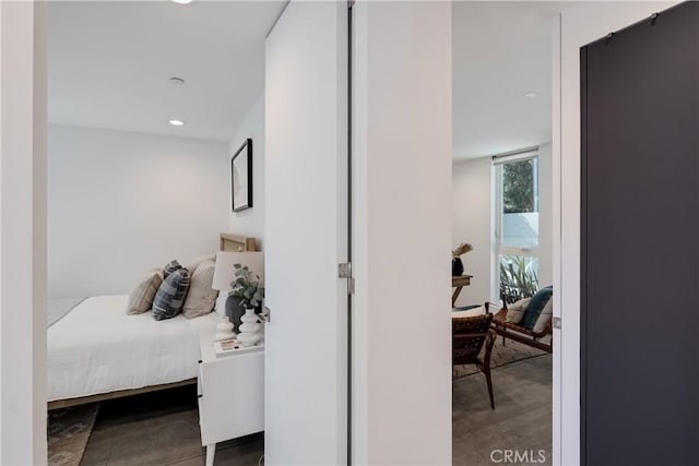 bedroom with floor to ceiling windows, wood finished floors, and recessed lighting