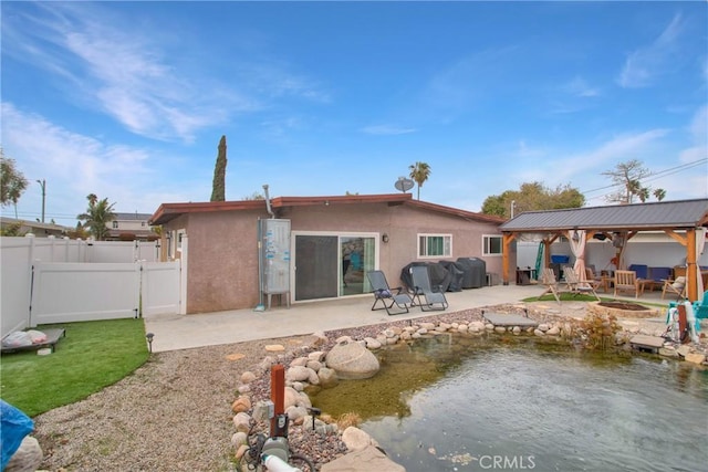 back of property with a gazebo, a patio, fence, and stucco siding