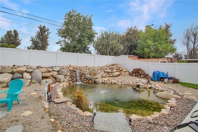 view of yard with a small pond and a fenced backyard