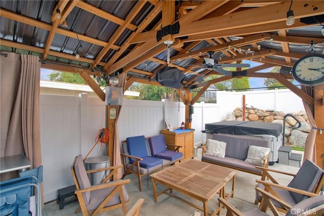 view of patio featuring a fenced backyard, ceiling fan, and a hot tub