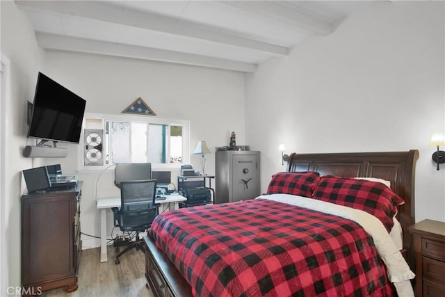 bedroom featuring beam ceiling and light wood-style floors