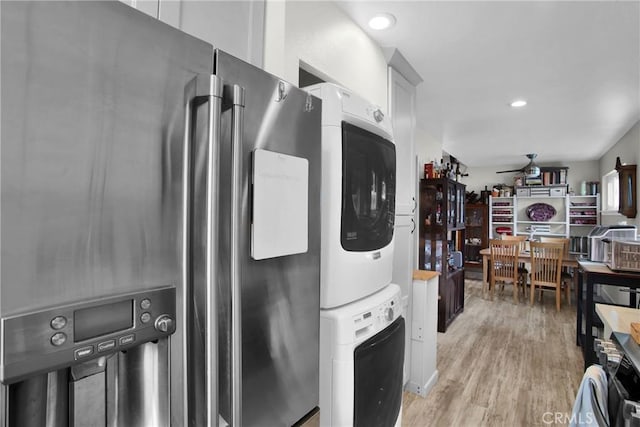 laundry room featuring ceiling fan, light wood-style flooring, recessed lighting, laundry area, and stacked washing maching and dryer