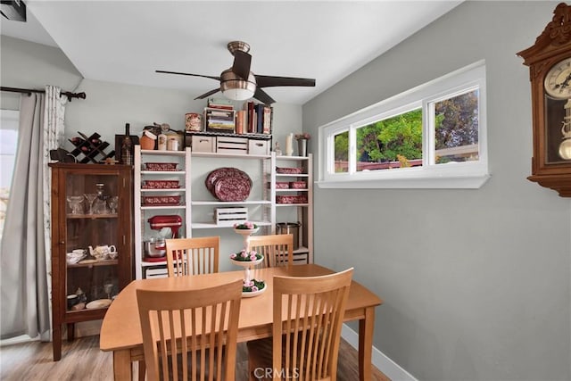 dining room featuring a ceiling fan, baseboards, and wood finished floors