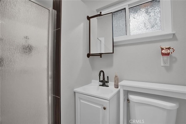 full bath with a stall shower, vanity, and toilet