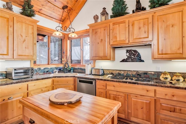 kitchen featuring butcher block counters, a sink, vaulted ceiling, appliances with stainless steel finishes, and light brown cabinetry