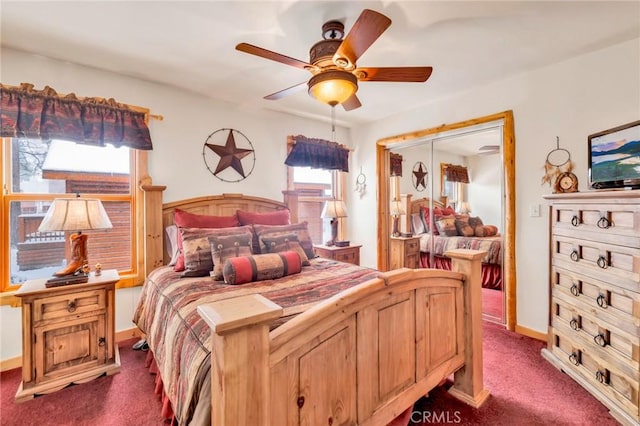 bedroom featuring multiple windows, dark carpet, a ceiling fan, and baseboards