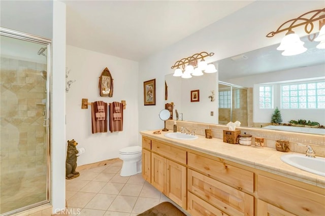 bathroom with double vanity, tile patterned flooring, a sink, and a shower stall