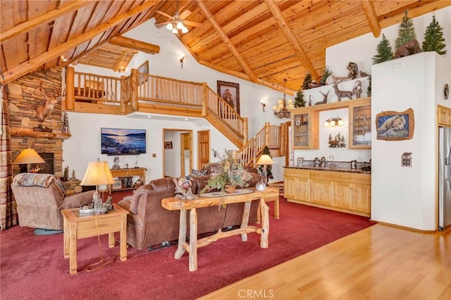 living area featuring wooden ceiling, stairway, dark wood-type flooring, beamed ceiling, and a fireplace