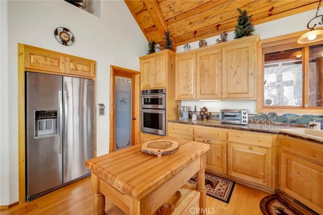 kitchen with a toaster, stainless steel appliances, and light brown cabinetry