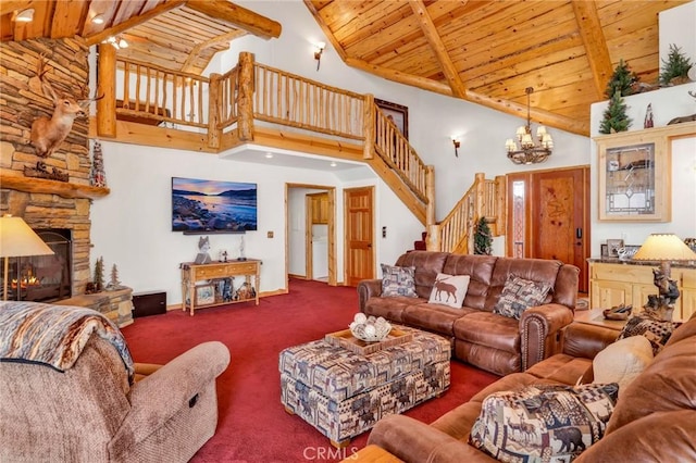 living room with wood ceiling, stairs, beamed ceiling, and a stone fireplace