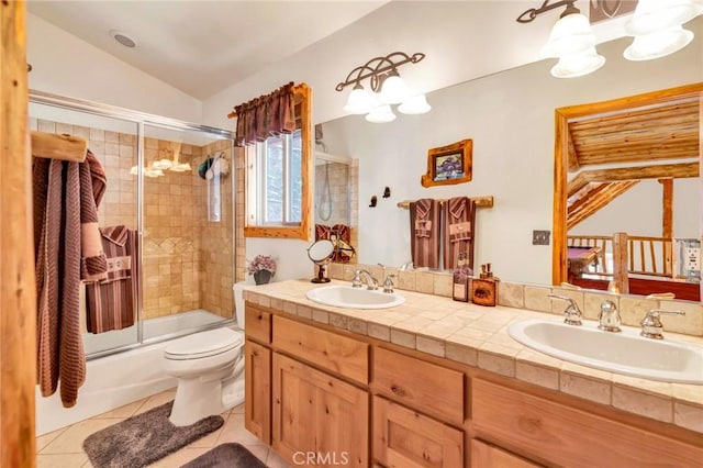 full bath featuring shower / bath combination with glass door, a sink, toilet, and tile patterned floors