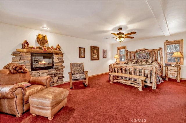 carpeted bedroom with a fireplace, baseboards, and ceiling fan