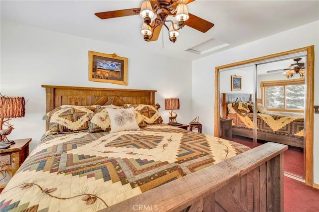 bedroom featuring dark carpet, attic access, and a ceiling fan