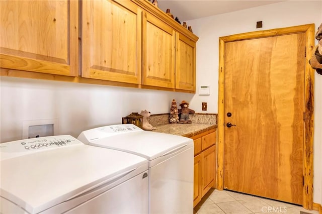 clothes washing area featuring separate washer and dryer, light tile patterned flooring, and cabinet space