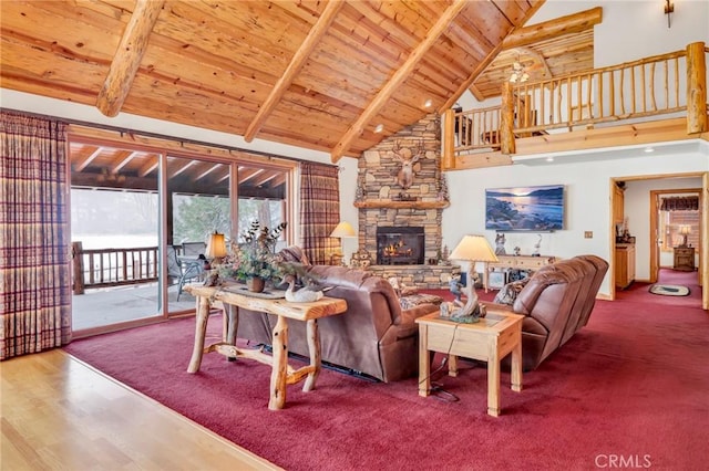 living room with high vaulted ceiling, a stone fireplace, wooden ceiling, and beam ceiling