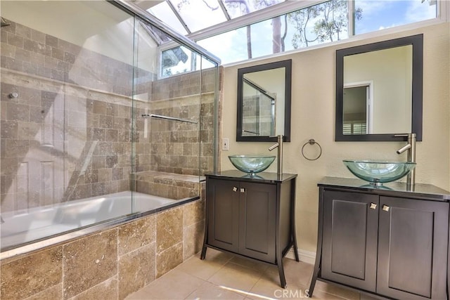 bathroom featuring tile patterned floors, two vanities, tiled shower / bath, and a sink