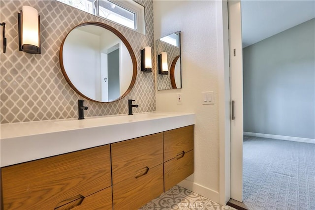 bathroom with double vanity, baseboards, and a sink