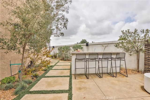 view of home's community featuring a patio, outdoor dry bar, and fence