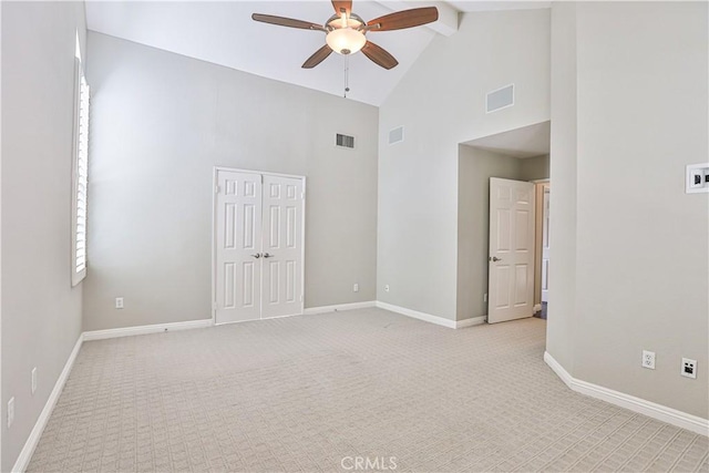 spare room with beamed ceiling, baseboards, visible vents, and light carpet