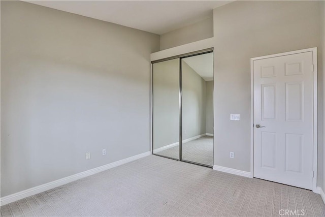 unfurnished bedroom with carpet, baseboards, and a closet