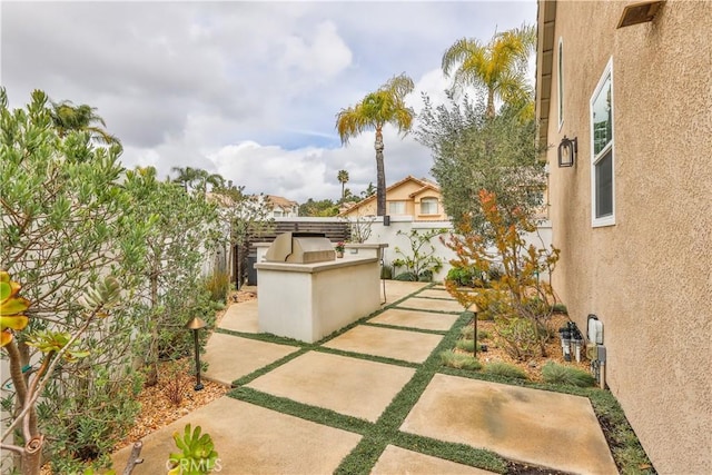 view of patio featuring exterior kitchen and fence