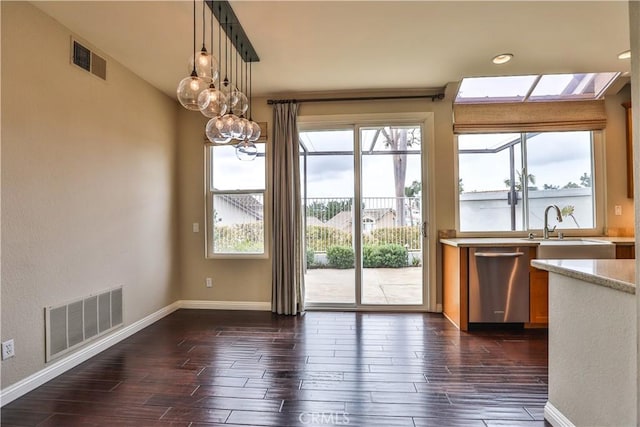 unfurnished dining area with dark wood-style floors, visible vents, and baseboards