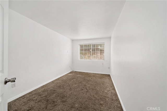 carpeted spare room featuring baseboards