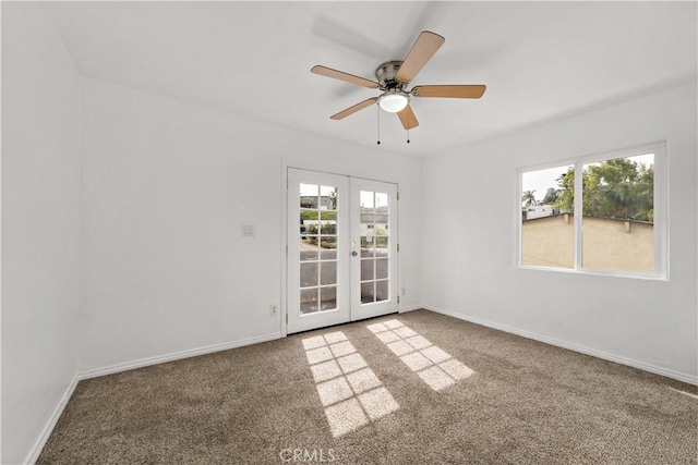 carpeted spare room with ceiling fan, baseboards, and french doors