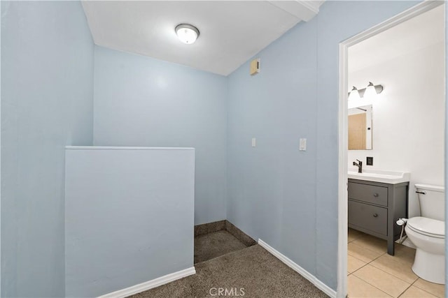 bathroom with baseboards, vanity, toilet, and tile patterned floors