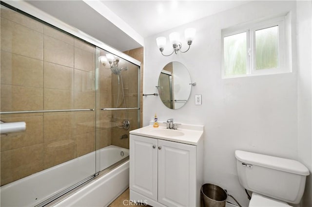 bathroom with combined bath / shower with glass door, vanity, and toilet