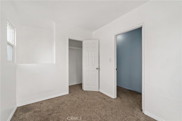 unfurnished bedroom with carpet floors, a closet, and baseboards