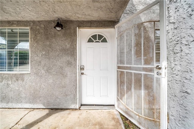 doorway to property featuring stucco siding