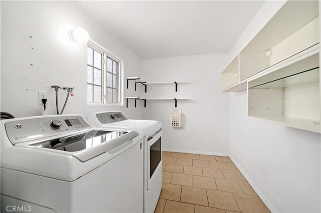 clothes washing area featuring laundry area, baseboards, light tile patterned flooring, and independent washer and dryer