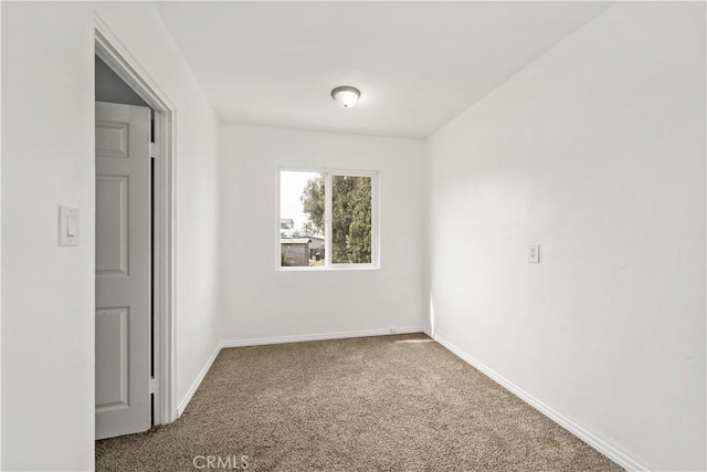 carpeted spare room with baseboards