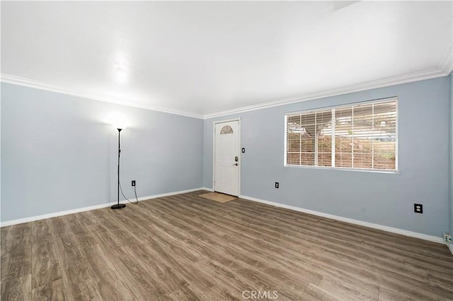 unfurnished room featuring crown molding, wood finished floors, and baseboards