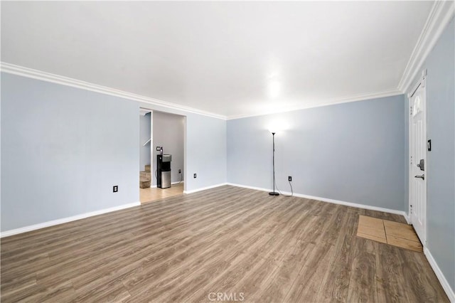 interior space featuring ornamental molding, wood finished floors, and baseboards